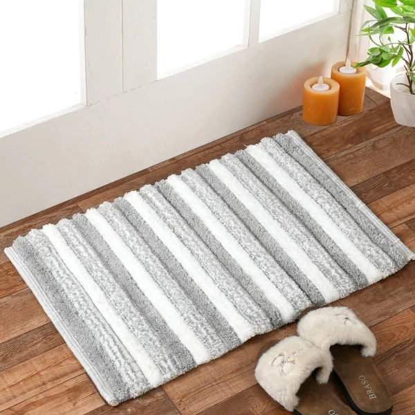 Tapis de salle de bain avec des chaussons et une paire de chaussures posés dessus.